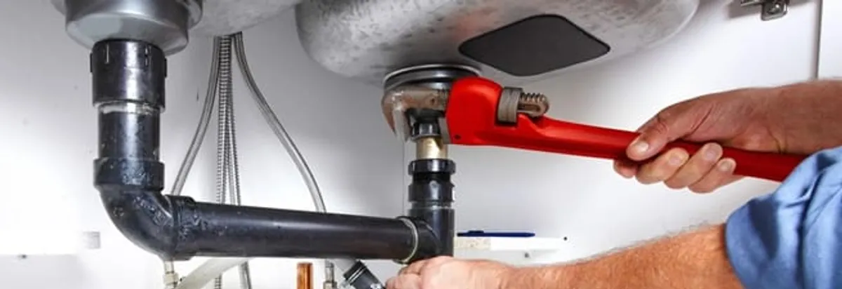 Garbage disposal repair technician tightening the sink drain and disposal connection in Chandler, AZ