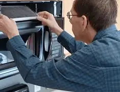 Appliance repair technician replacing a microwave vent filter in Chandler, AZ