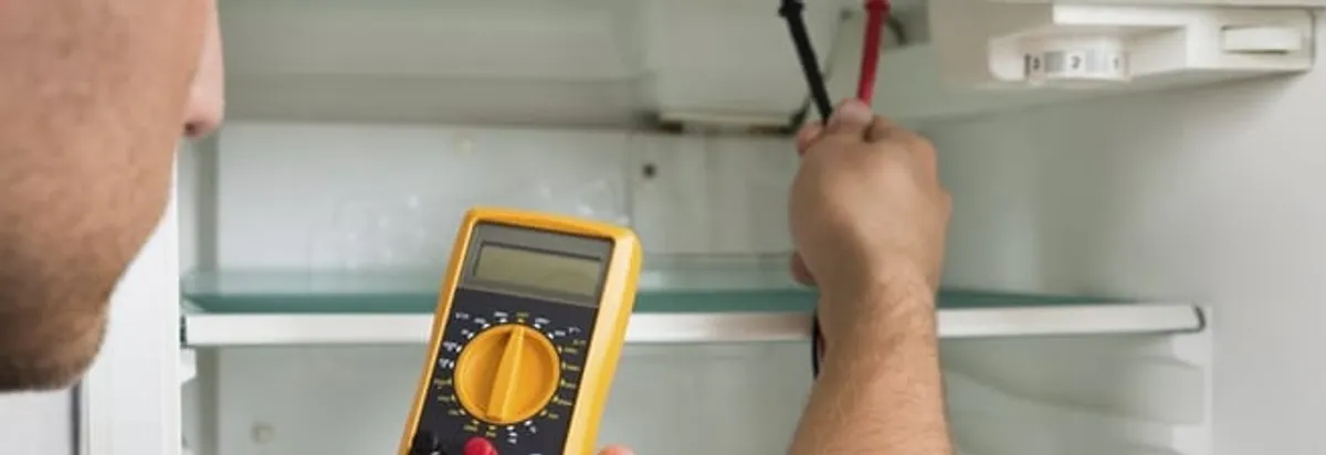 Refrigerator repair technician testing electrical components with a multimeter in Chandler, AZ