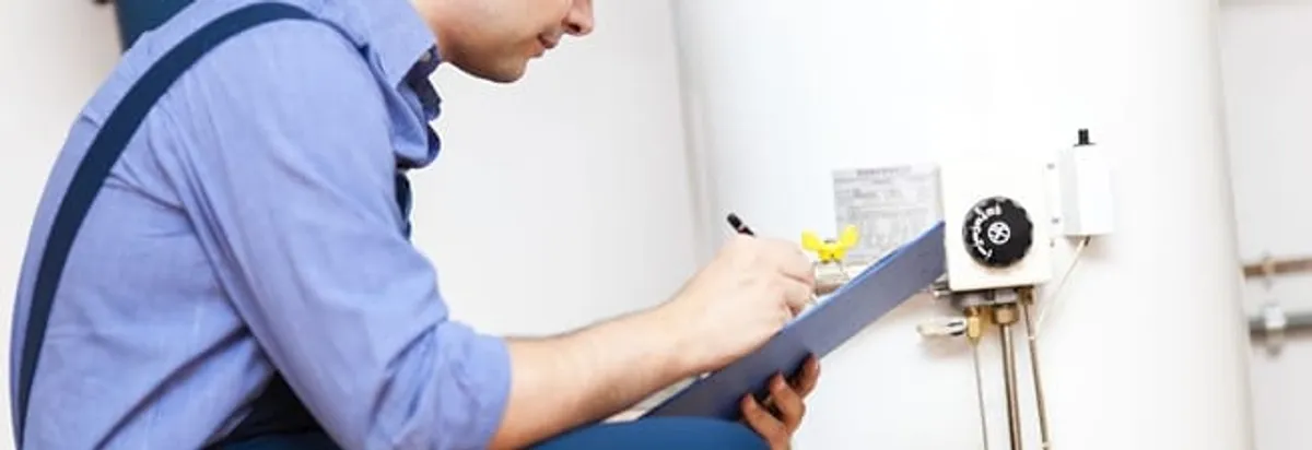 Water heater repair technician inspecting the unit and recording service notes in Chandler, AZ